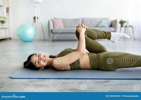 Lovely Indian Woman Stretching Her Leg While Lying On Mat Indoors Stay Home Sports Stock Image