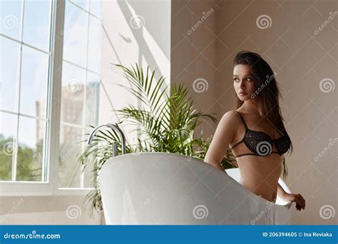 Model Girl With Perfect Slim Body In Beige Lingerie In Bathtub Stock