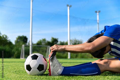 Football Soccer Player Stretching During Warm Up Before Kick Ball In