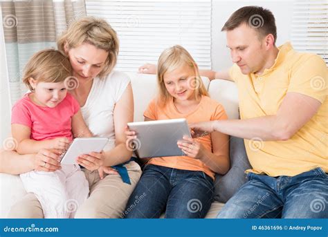 Familia Joven Usando La Tableta Junto Foto De Archivo Imagen De