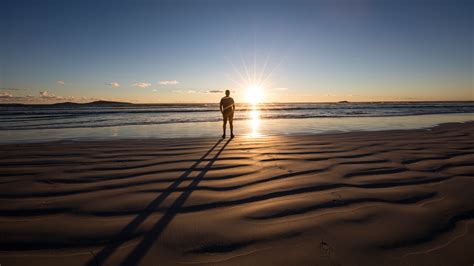 Man Standing On Beach Looking At The Sunset Western Australia