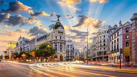 Download 1600x900 Madrid Sunset Buildings Clouds Road Lights