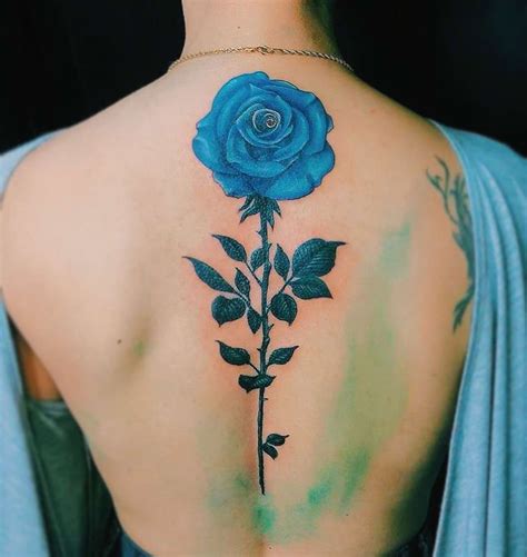A Woman With A Blue Rose Tattoo On Her Back