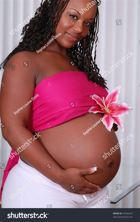 Beautiful Pregnant African American Woman Holding A Pink Flower On Top