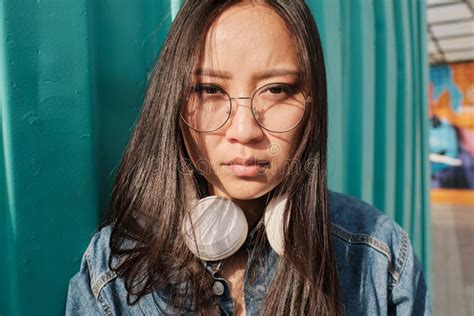 Portrait Of An Asian Girl Wearing Glasses And Headphones Stock Image
