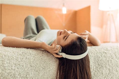 Pretty Teenage Girl Lying On Bed And Listening To Music Stock Image