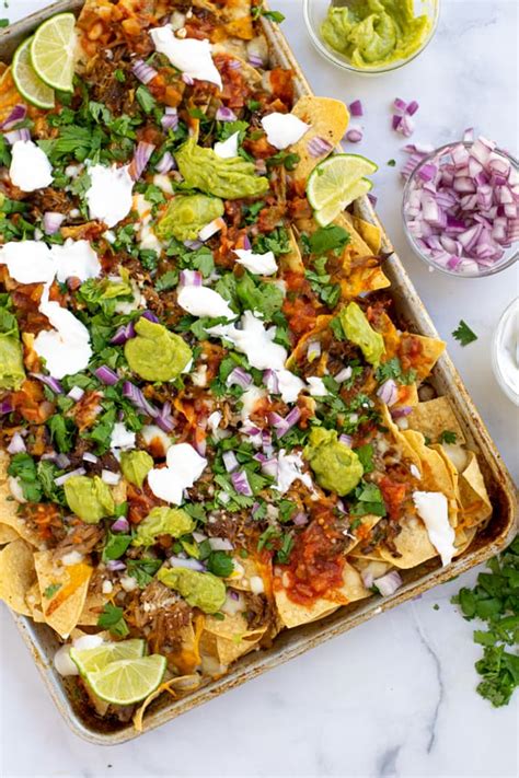 This recipe gives you both options of cooking in either the slow cooker or instant pot so use whichever you own for incredible results either way! Loaded Pork Carnitas Nachos | The Schmidty Wife