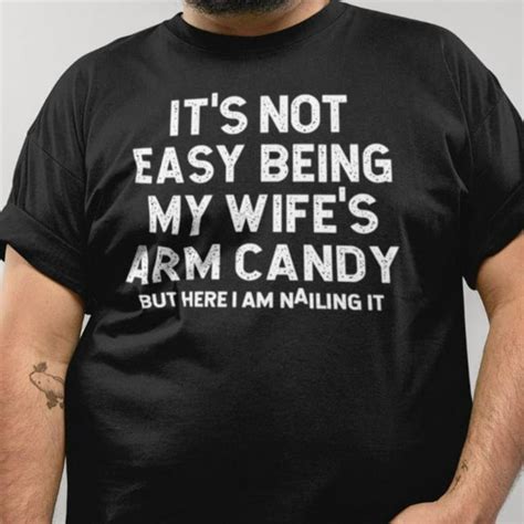 it s not easy being my wife s arm candy but here funny husband men s t shirt