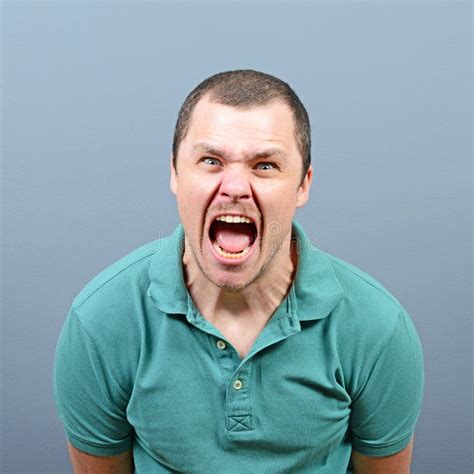 Portrait Of Angry Man Screaming And Pulling Hair Against Blue Ba Stock