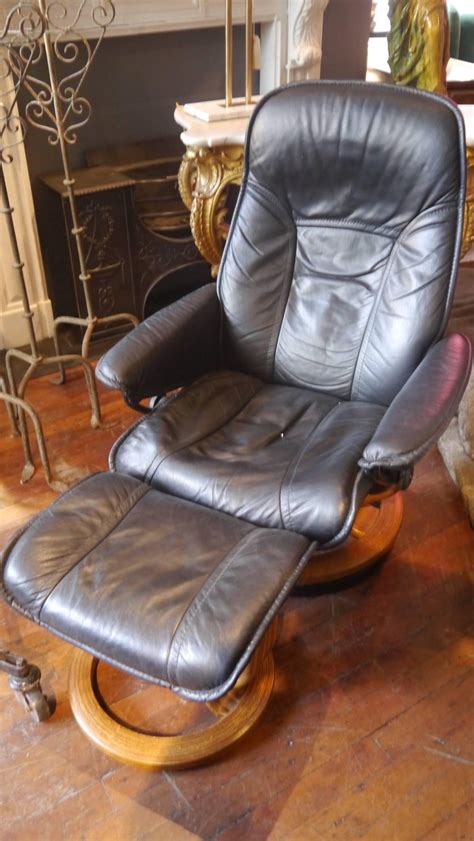 Available in colors including red, white, black, cream, and beige, leather rolling office chairs or armchairs can make you more productive and comfortable at your desk. 1970s Black Leather Reclining Chair with Foot Stool For Sale at 1stdibs