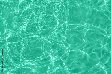 Closeup Of Calm Clear Water Surface With Water Splashes In Trendy Mint Color Swimming Pool