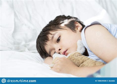 Kid 6 7 Year Old Lying On Bed Sleepy Child Waking Up The Morning In