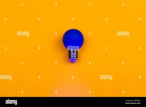 Blue Light Bulb On A Yellow Background Single Bulb With Copy Space
