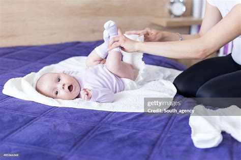 Young Mother Is Changing Diapers To Her Baby Girl High Res Stock Photo