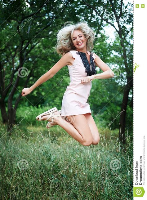 Beautiful Happy Young Woman Jumping High In Air In The