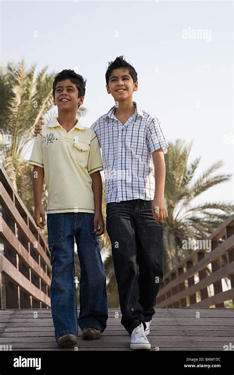 Two Boys Walking Along A Bridge Stock Photo Alamy