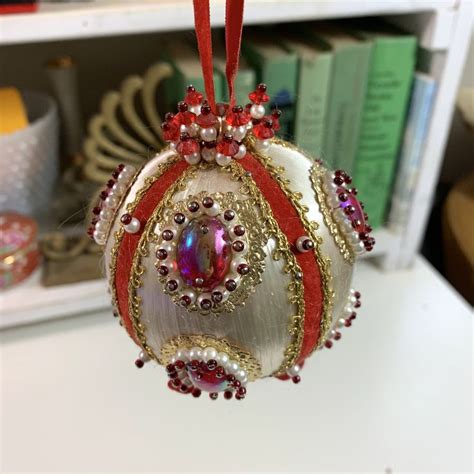 A Christmas Ornament Hanging From A Red Ribbon On A White Countertop In