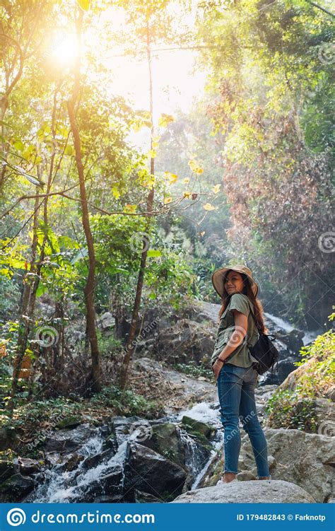 A Woman Standing In Front Of Waterfall In The Jungle Stock Image