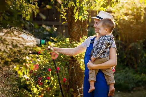 Woman Gardener With Son Watering Garden Stock Image Image Of Outdoors