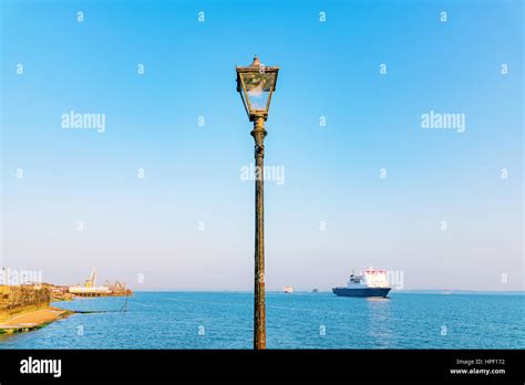 Lamp Post With Blue Sky Ocean And Ship In The Background Stock Photo