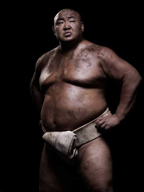 A Sumo Wrestler Posing For The Camera With His Hands On His Hips And