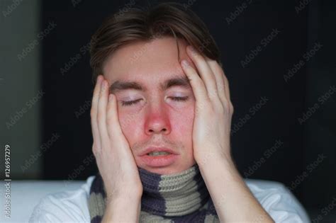 A Young Man Suffering From A Cold Chills Headache And Stuffy Nose