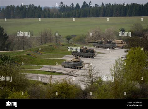 A Group Of M1 Abrams Main Battle Tanks And Bradley Fighting Vehicles