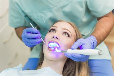 Dentista Que Hace Procedimiento Con La Luz Uv De Curado Dental En Cl Nica Foto De Archivo