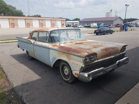 an old rusted out car is parked on the side of the road in front of a