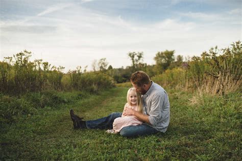 Daughter Sitting On Fathers Lap On Grass Cuf Erin Lester Westend