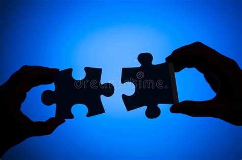 Hands Trying To Fit Two Puzzle Pieces Together Stock Image Image Of