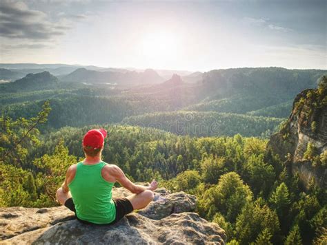 Man Meditates In Yoga In Mountains Above Wild Nature At Sunset Concept