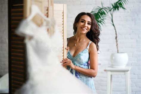 Beautiful Girl Getting Ready For The Wedding A Dress Hanging On A