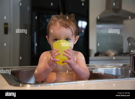 14 Month Old Girl Having A Bath In The Kitchen Sink Stock Photo Alamy