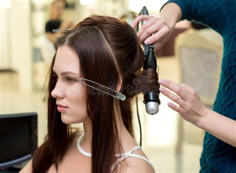 hair stylist making ringlets to brunette woman hairdresser work stock image image of