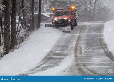 Snowplow In Action Clearing Residential Roads During Snow Storm Stock