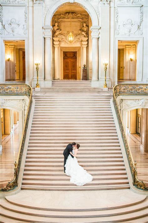 A Bride And Groom Kissing On The Steps Of An Ornate Building
