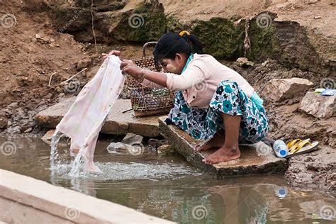 A Young Burmese Woman Is Washing Clothes In The Irrawaddy River
