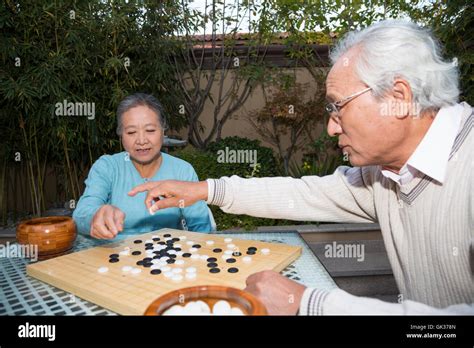 Old Couple Playing Chess In The Garden Stock Photo Alamy