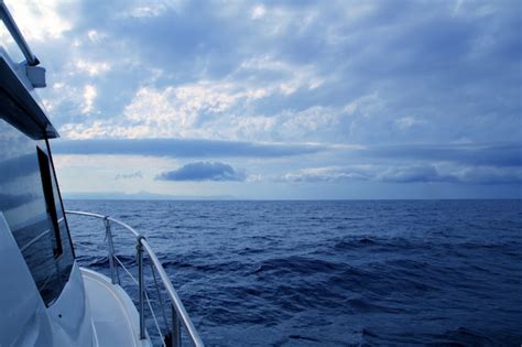 Premium Photo Boat Sailing In Cloudy Stormy Day Blue Ocean