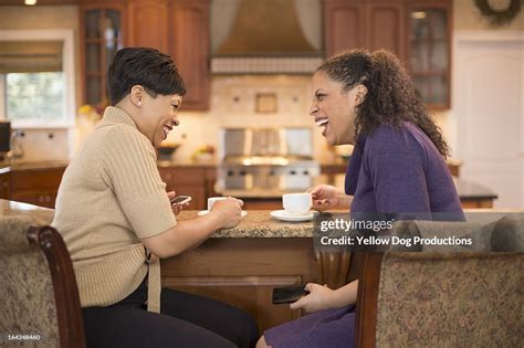 Women Friends Laughing And Having Coffee Together Stock Photo Getty