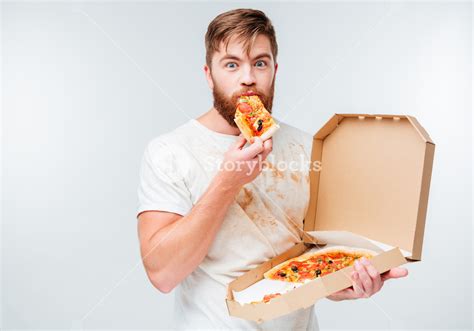 happy hungry man eating pizza from a box isolated on white background royalty free stock image