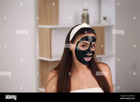 Young Woman With Carbon Detox Black Mask On Face Teenage Girl Takes Care Of Oily Skin