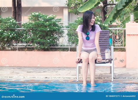 asian woman resting at poolside with both feet on the water stock image image of blue resort