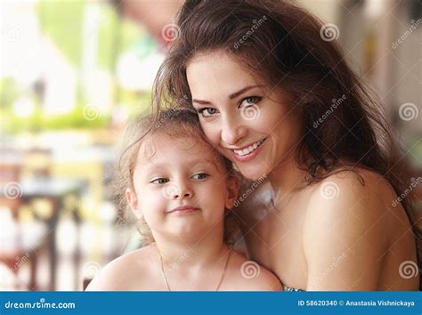 Happy Smiling Mother Cuddling Her Cute Daughter In Restaurant Stock