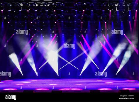 Illuminated Empty Concert Stage With Haze And Rays Of Red Purple And