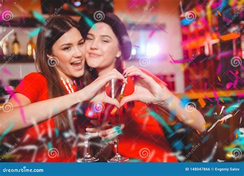partie de confettis deux jeunes filles lesbiennes font un coeur avec leurs mains une partie de