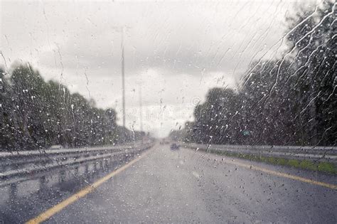 Road View Through Windshield Car Window With Going Rain Drops During