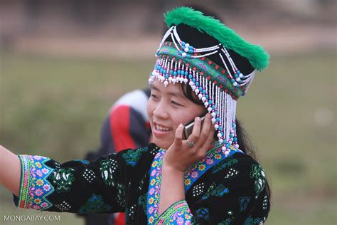 Hmong girl in traditional apparel talking on a mobile phone while ...