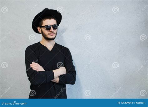 Portrait Of Hipster Man Dressed In Black With Sunglasses And Hat On White Background Stock